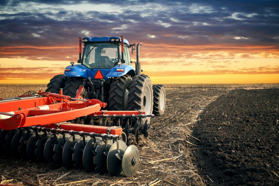 Tractor working on the farm, modern agricultural transport, farmer working in the field, tractor on a sunset background, cultivation of land, agricultural machine